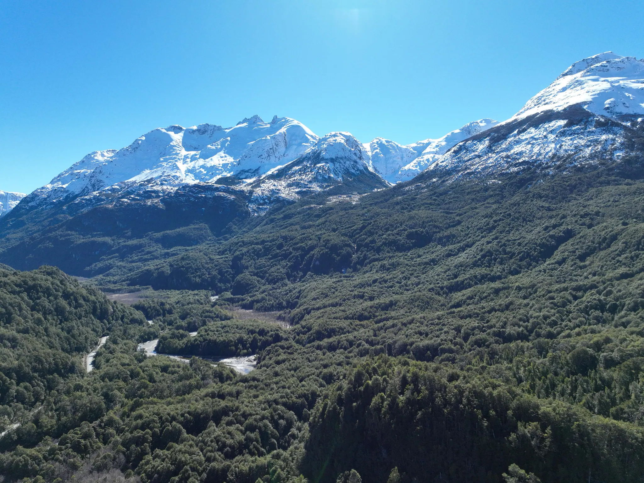 Bosque nativo y montañas nevadas en el sector Río Exploradores