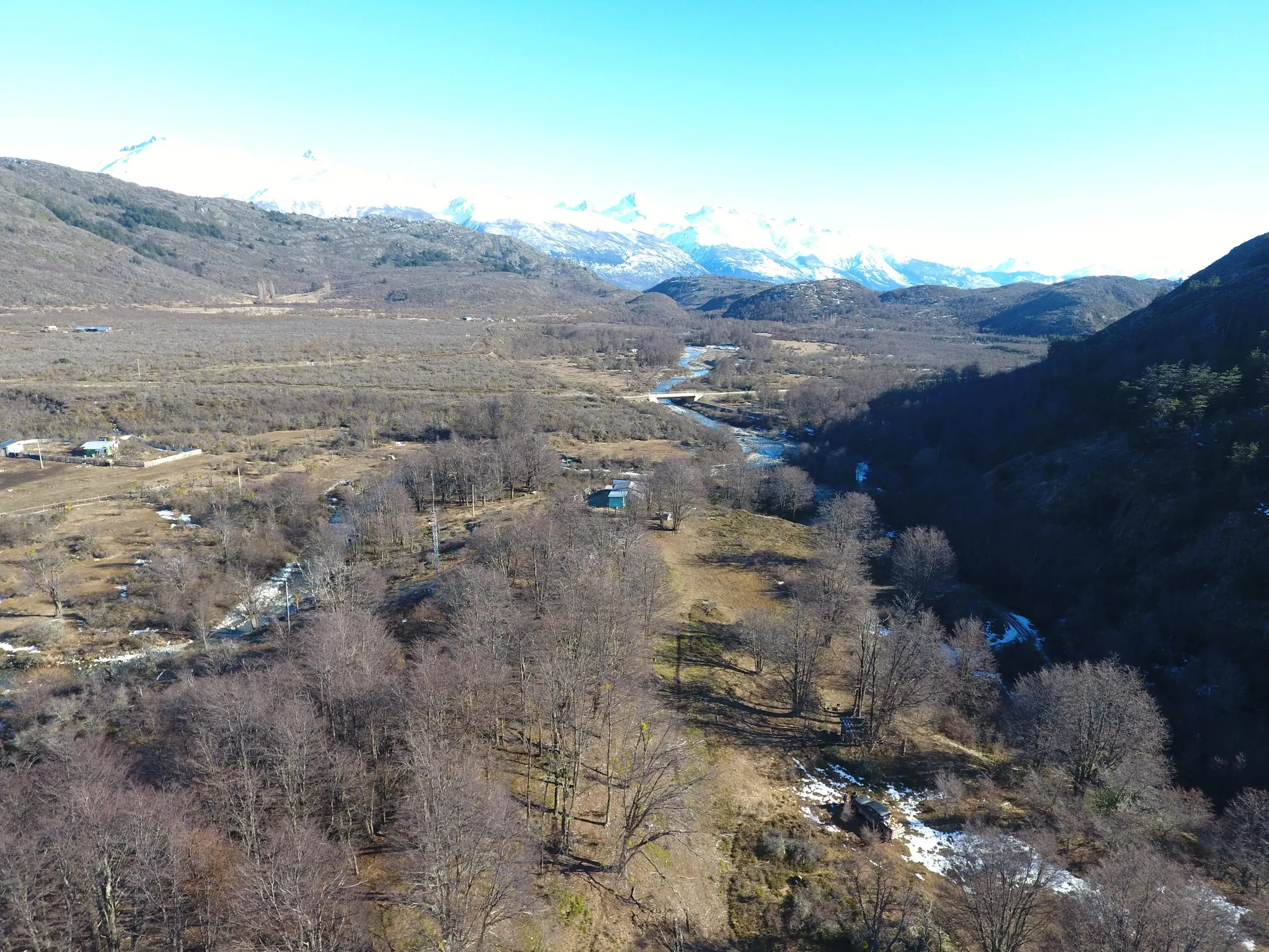 Vista aérea del sector Río Bertrand, con el río, bosque y la cordillera nevada al fondo