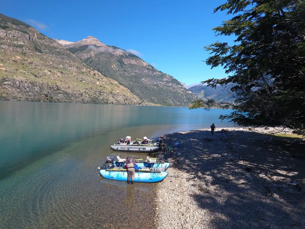 Botes en la orilla de piedras del Lago Azul